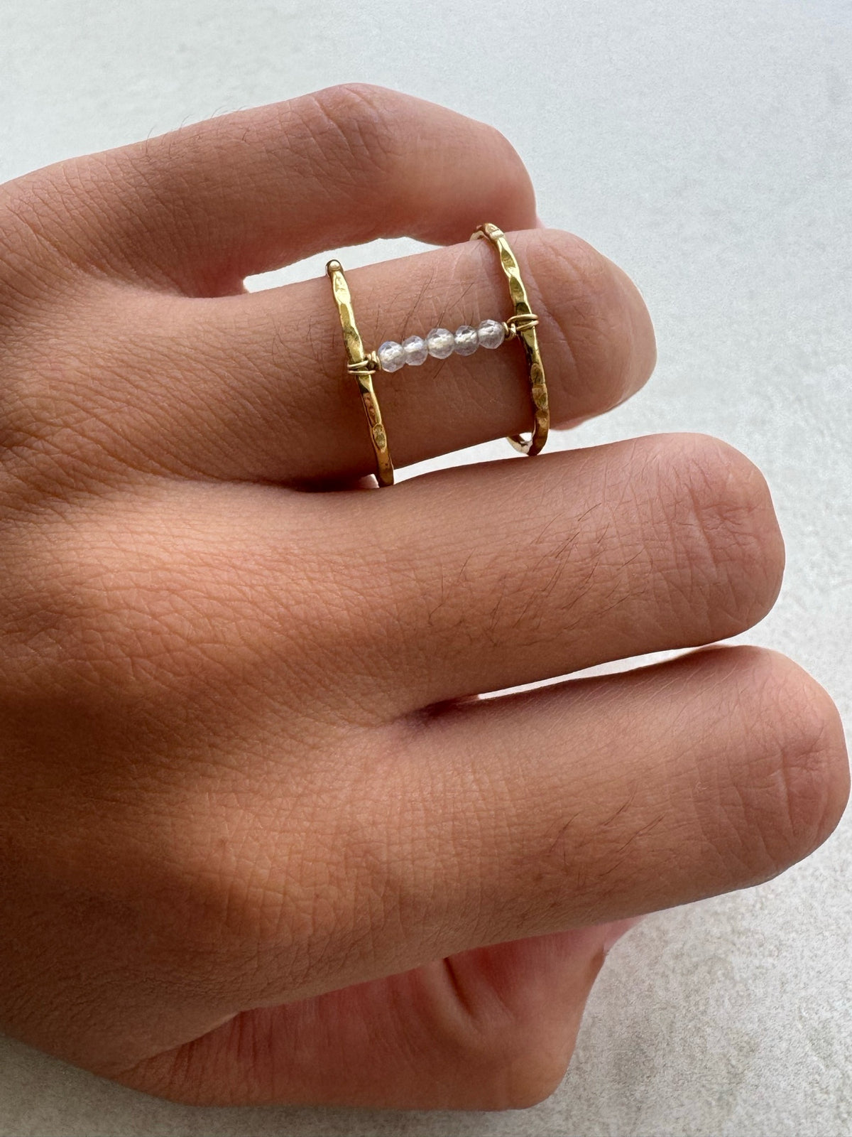 Anillo Iris dorado con labradorita puesto en la mano